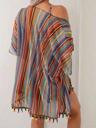 Multicolored striped dress with tassels on a plain background