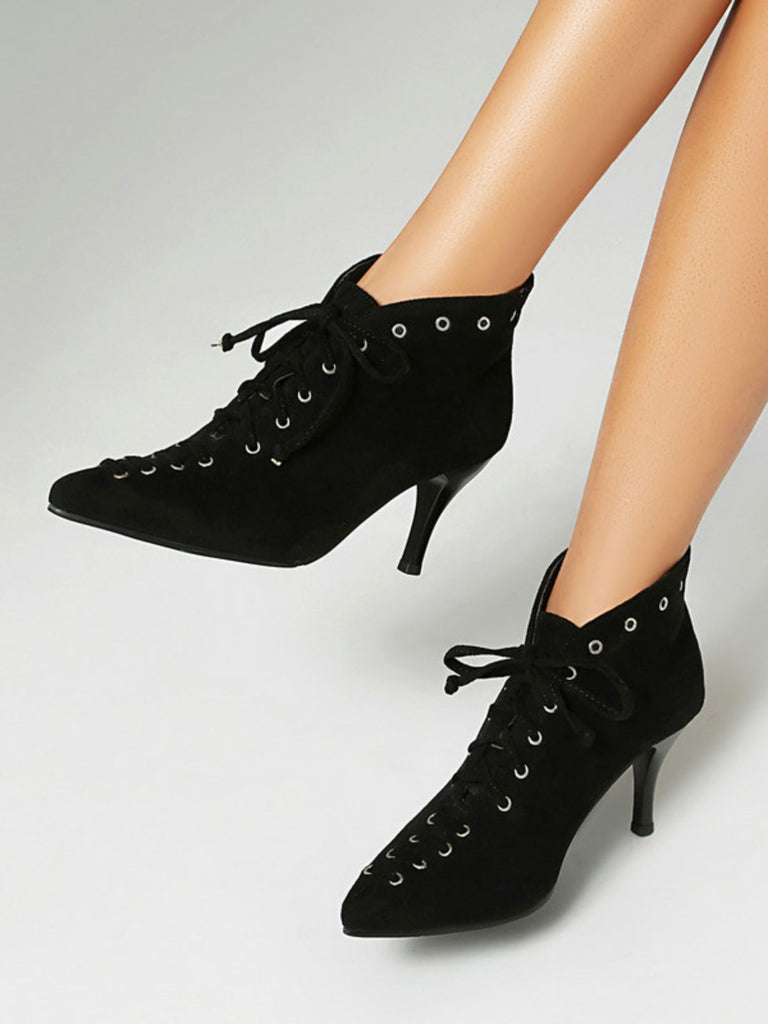 Black high-heeled lace-up shoes on a neutral background