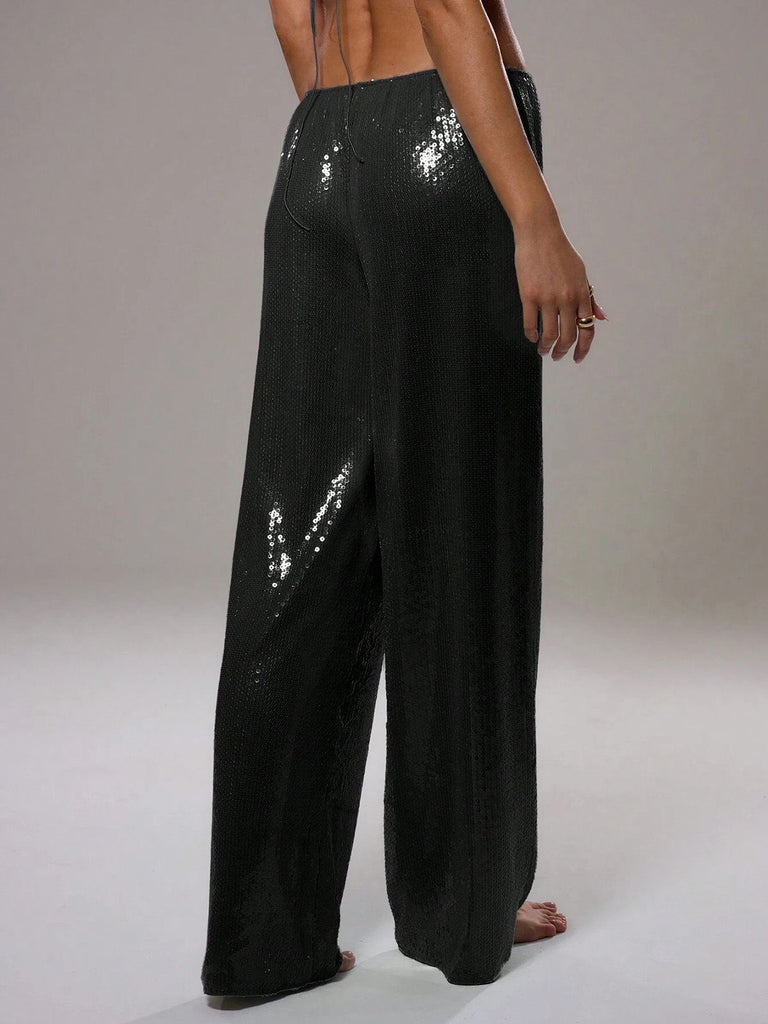 Black sequin pants worn by a person on a plain background