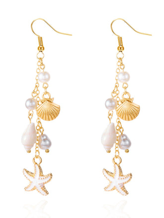 Boucles d'oreilles en or et perles ornées d'étoiles de mer et de coquillages sur fond blanc