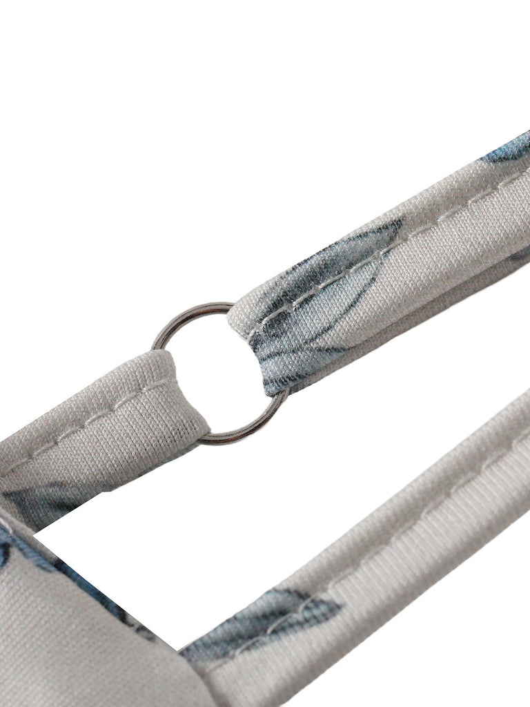 Close-up of a floral-patterned strap with a metal ring on a white background