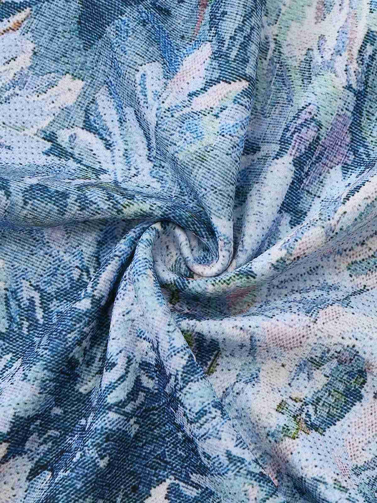 Close-up of textured fabric with floral pattern in blue, white, and pink.