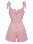 Pink romper with bow straps on a white background