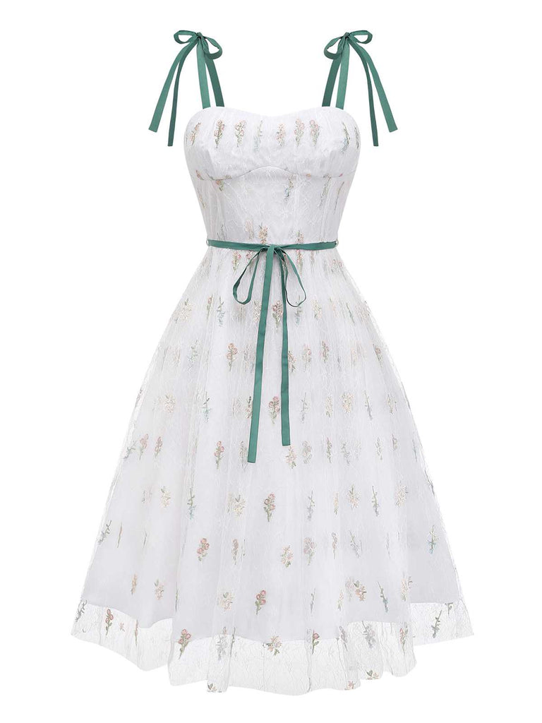 Vue de face en studio de la robe en résille blanche mettant en valeur le décolleté en cœur et la jupe à volants.