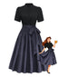 Robe noire col montant et tablier motifs floraux années 1950