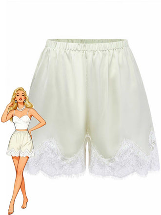 Short de pyjama taille haute en satin crème avec un ourlet en dentelle florale blanche délicate, présenté à côté d'une illustration de mode rétro de style pin-up.