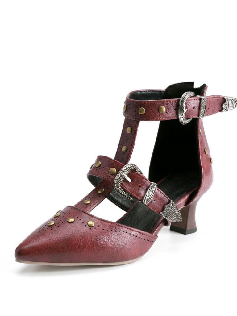 Red high-heeled shoe with buckles and stud details on a white background