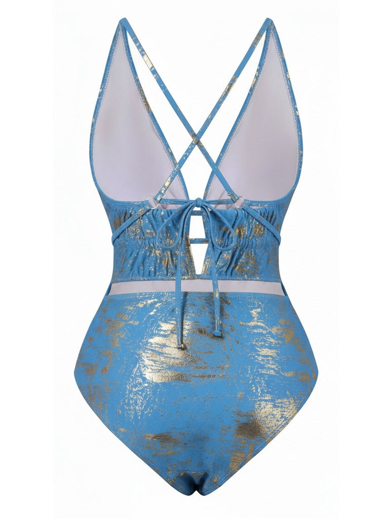 Blue and gold patterned swimsuit with criss-cross straps on a white background