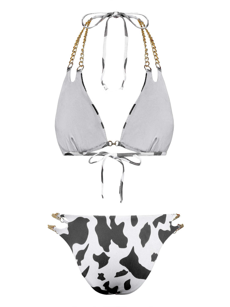 Back view of the black and white cow print bikini showcasing the tie closures and gold chain strap detailing.