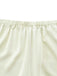 Close-up of the gathered elastic waistband on the cream satin pajama shorts.