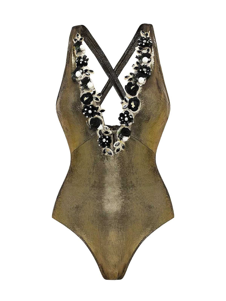Studio front view of the metallic gold one-piece highlighting the intricate floral trim along the plunging neckline.