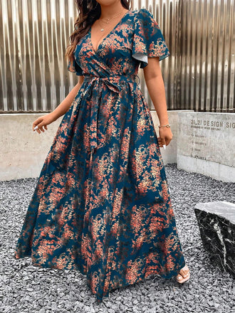 Full-length outdoor view of the teal and rust floral wrap dress highlighting the flowy skirt and waist tie.