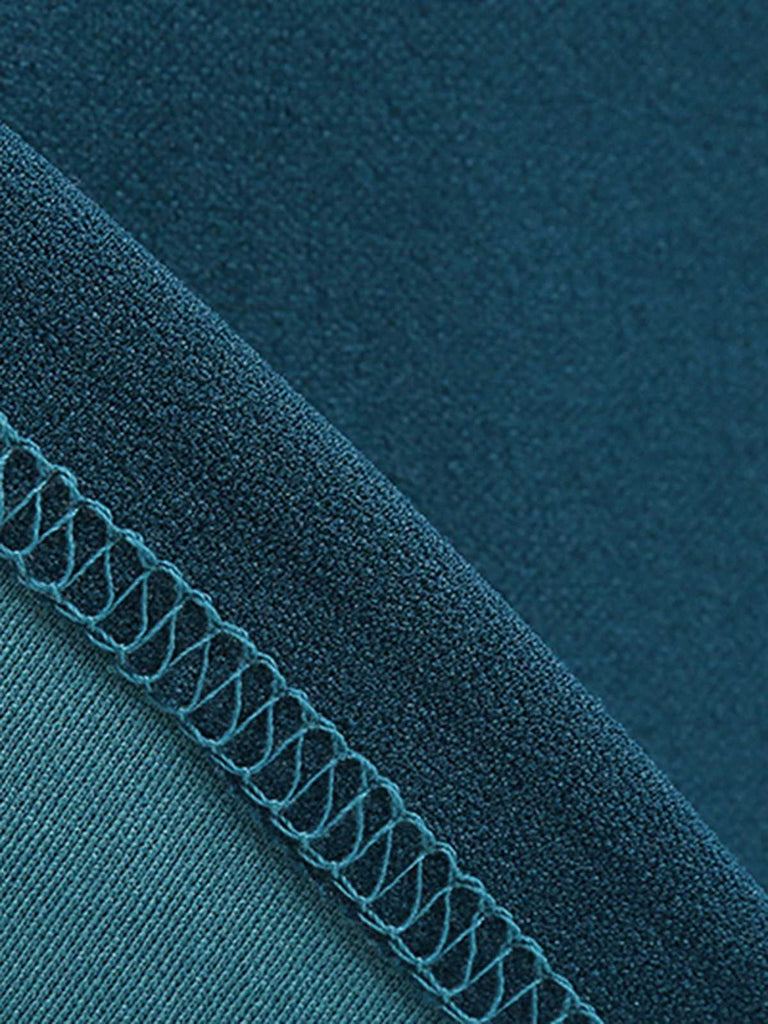Close-up of teal fabric with a zipper and stitching detail