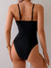 Rear view of a model wearing the black swimsuit, showcasing the high-cut leg and back strap positioning.