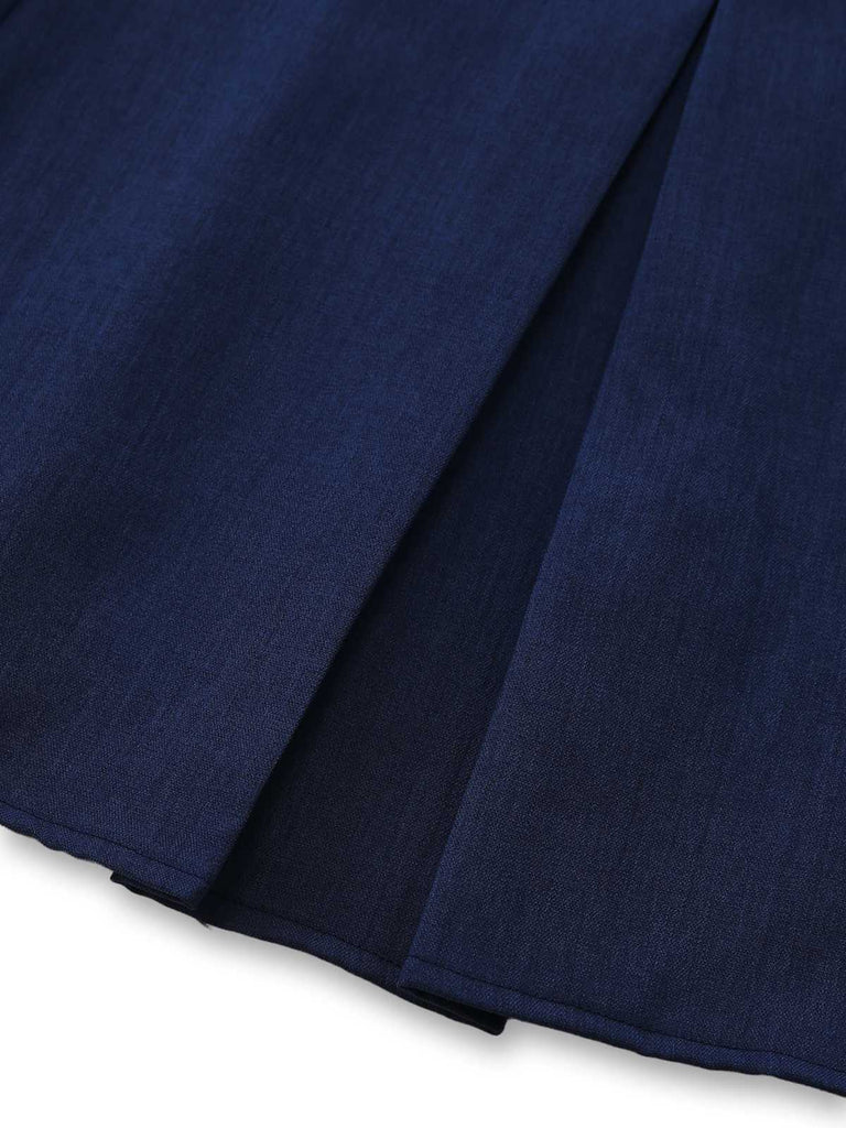 Close-up of the vertical pleat construction near the skirt's hemline.