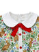 Close-up of the white Peter Pan collar featuring a decorative red velvet-style bow and red buttons.