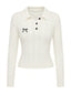 Pull polo blanc maille torsadée orné d’un nœud brodé années 1950