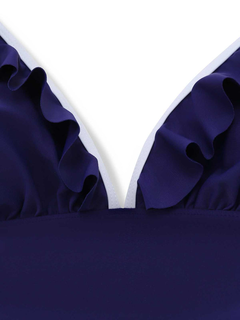 Close-up of the delicate ruffled trim along the deep V-neckline of the navy blue halter swimsuit.