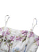 Close-up of the sweetheart neckline and thin spaghetti straps on the purple floral print dress.