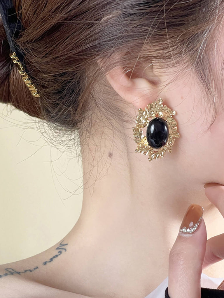 Boucles d'oreilles avec pierres précieuses noires cerclées d'or