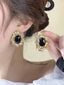 Boucles d'oreilles avec pierres précieuses noires cerclées d'or